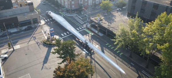 Aerial view of a turbine blade moving through a city street grid