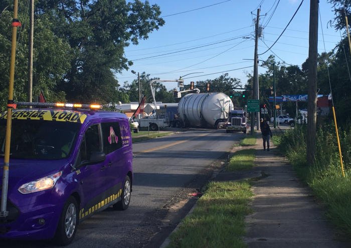 An FT&L pilot car leading an over-dimensional load through a small town