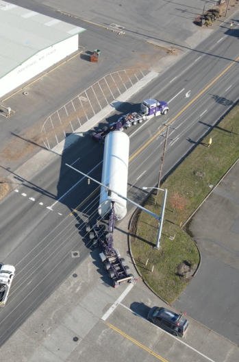 Drone view of a long FT&L oversize load turning through a town intersection