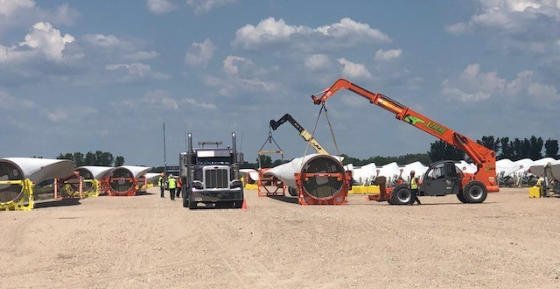Crane and trailers working a laydown yard staging wind components
