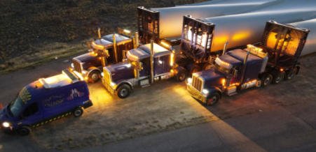 FT&L trucks staged at night with running lights illuminated
