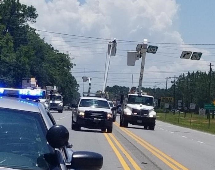 Police escort leading an FT&L convoy through traffic