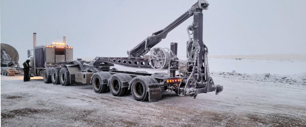 Specialized trailer and crane gear working in blowing snow